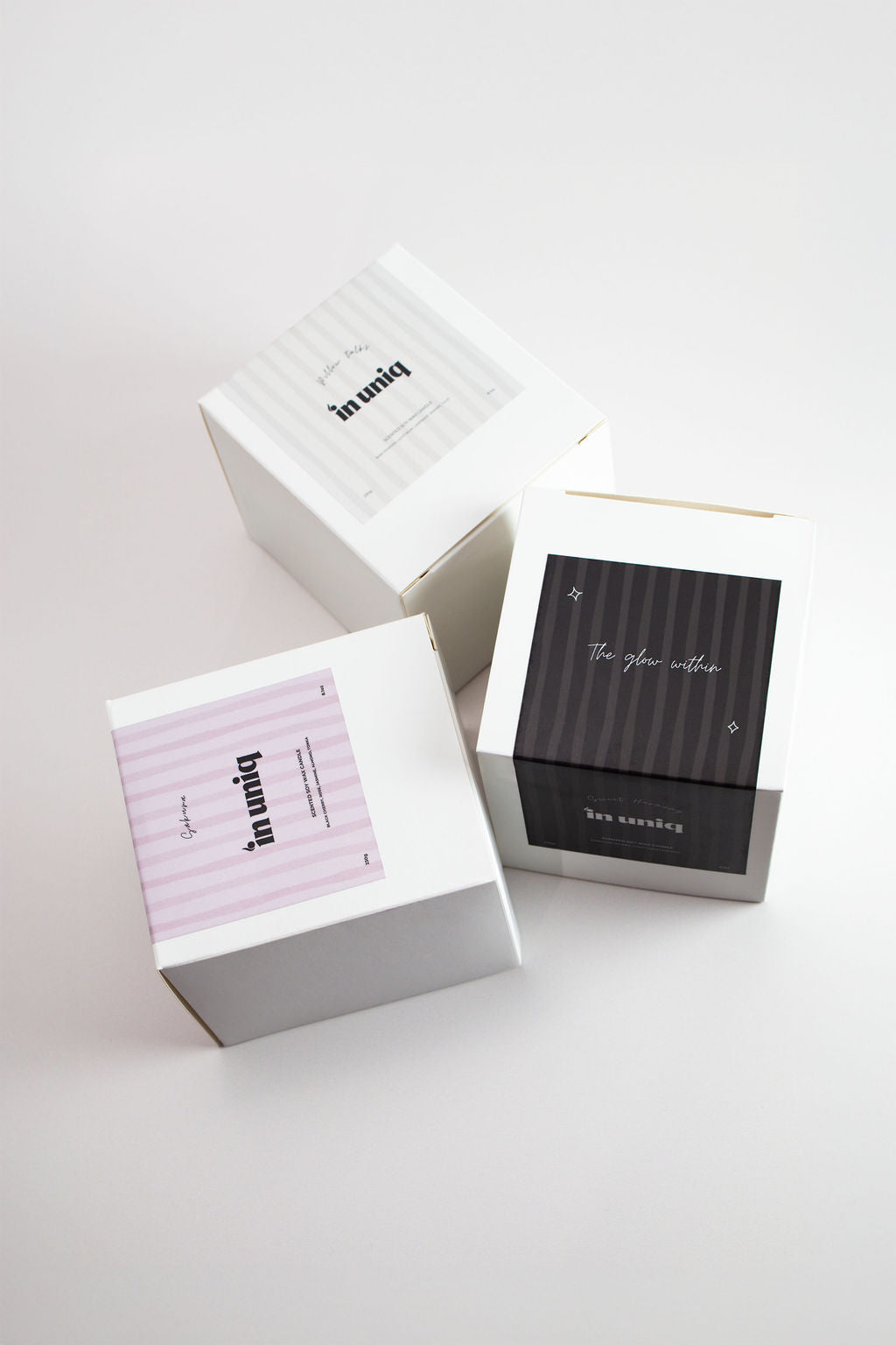 Three premium gift boxes arranged on a clean white surface. One box is white with light pink horizontal stripes and the text 'bipin up', another is white with a black striped panel and white script text, and the third is white with a black striped panel and 'ben carbon' printed on it.